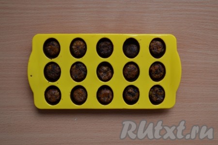 Когда застынет шоколад, выложить в каждую ячейку шарик из сухофруктов.
