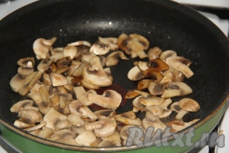 Шампиньоны промыть, нарезать на пластины и выложить на сковороду, разогретую с растительным маслом. Обжарить грибы на небольшом огне до готовности (в течение 8-10 минут).
