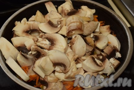 К морковке, обжаренной с луком, добавляем шампиньоны и перемешиваем, жарим грибы с овощами на медленном огне, примерно, 8-10 минут.

