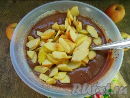 Выложите кусочки нарезанных яблок в шоколадное тесто и перемешайте.

