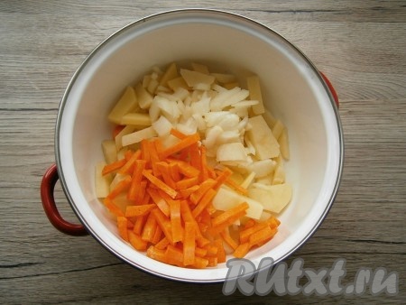 В кастрюлю с картошкой выложить мелко нарезанный репчатый лук и нарезанную соломкой или брусочками морковь.
