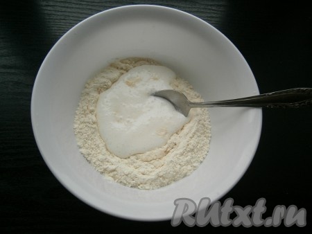 Муку насыпать в миску, добавить соль, сделать углубление и влить кефир.
