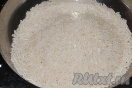 Рис промыть и отправить в кастрюлю вслед за луком с томатной пастой, добавить лавровый лист, соль по вкусу.