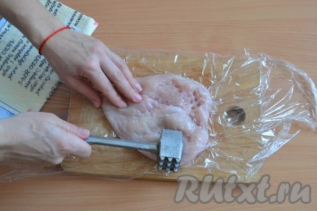Накрыть филе пищевой пленкой и аккуратно, легенько отбить молотком с одной стороны. Аналогично подготовить отбивную из второго куриного филе.