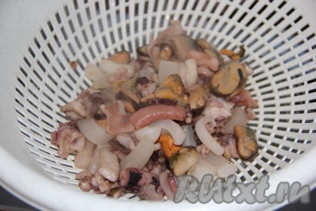 Затем откинуть морепродукты на дуршлаг и дать стечь лишней жидкости.