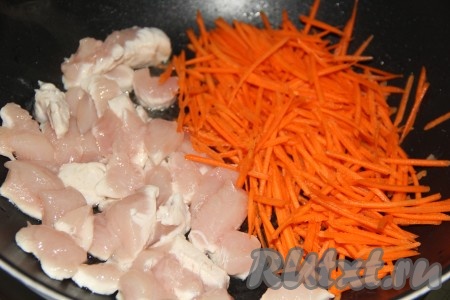 В сковороду с высокими бортиками добавить масло, хорошо нагреть и выложить нарезанную куриную грудку и натёртую морковь.
