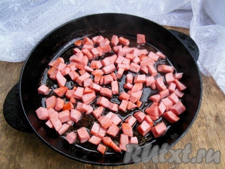 Колбасу нарежьте на небольшие кубики. Обжарьте колбасу до золотистого цвета со всех сторон (в течение 1-2 минут) на сковороде, хорошо разогретой с растительным маслом.
