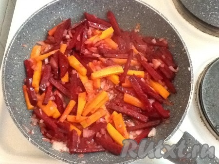 Нарезать лук мелко и обжарить на сковороде на подсолнечном масле, помешивая, до прозрачности. Затем добавить к луку нарезанные соломкой свёклу и морковь. Продолжать обжаривать овощи, помешивая, на среднем огне в течение 5-7 минут.
