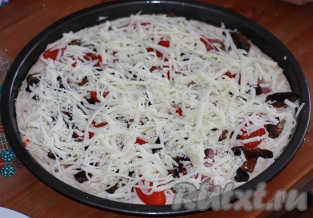 Сыр "Моцарелла" натереть на терке, выложить сверху на пиццу. Форму с пиццей поставить в разогретую до 160 градусов духовку и выпекать до готовности. Пицца сверху должна покрыться румяной корочкой, а тесто хорошо пропечься.
