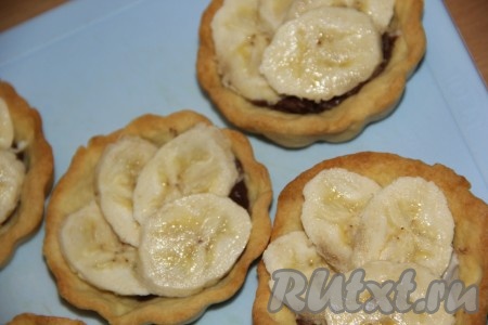 Бананы очистить, нарезать на кружочки и выложить поверх шоколадной пасты по 4 кружочка банана.
