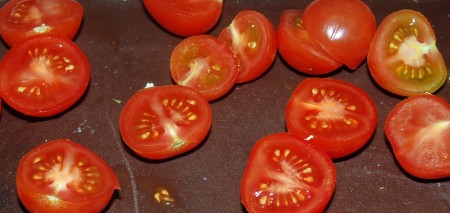 Нарезать помидоры черри на половинки.