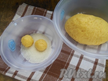 Чтобы сформировать печенье, разделите тесто на небольшие шарики, скатайте их в ладошках. В тарелку насыпьте сахар и обмакните шарики с одной стороны.