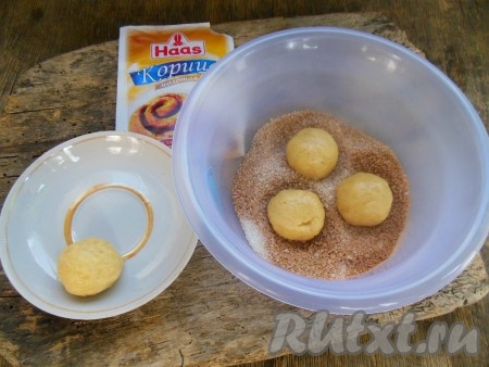 Каждый шарик из теста обмакните с одной стороны в смесь сахара и корицы.
