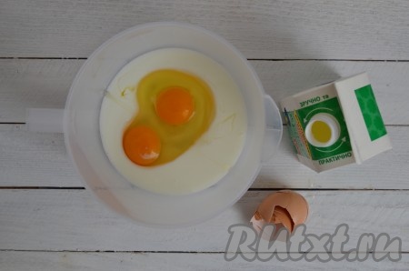 В глубокую миску влить кефир комнатной температуры и добавить куриные яйца.
