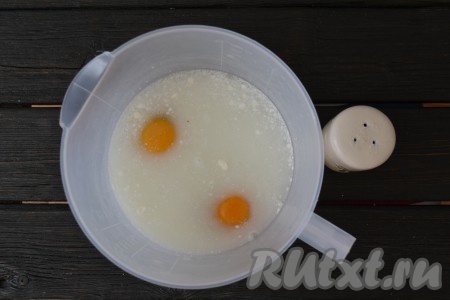 В глубокую миску влить сыворотку или воду. Желательно, чтобы они были комнатной температуры. Добавить куриные яйца и щепотку соли.
