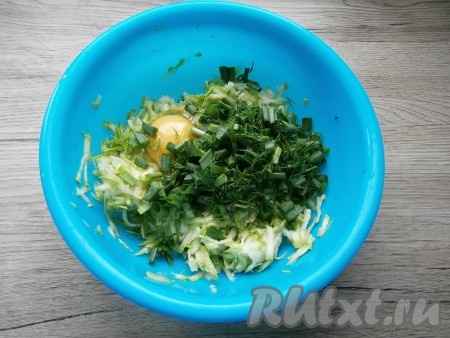 К натертым кабачкам добавить сырое яйцо, мелко нарезанные зелёный лук и укроп.
