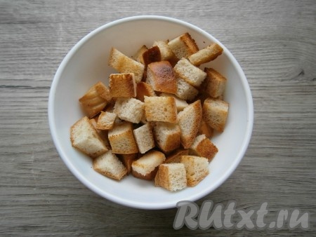 На сухую сковороду выложить батон или хлеб, нарезанный небольшими кубиками, и подсушить, иногда помешивая, до состояния сухариков, остудить.
