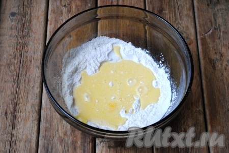 Влить молочно-масляную смесь в смесь муки, сахара и разрыхлителя, тщательно перемешать тесто ложкой.
