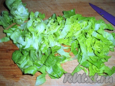 Листья салата тоненько нарезать и выложить в посуду для приготовления салата. 