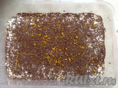 Выложить поверх второго слоя печенья оставшийся взбитый сыр Маскарпоне, посыпать тертым шоколадом и цедрой.