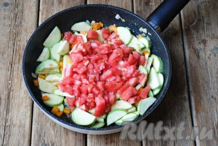 Выложить кубики помидоров в сковороду к обжаренным овощам.

