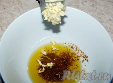 Налить в мисочку оливковое масло, добавить измельченную зиру, пропущенный через чеснокодавилку чеснок.