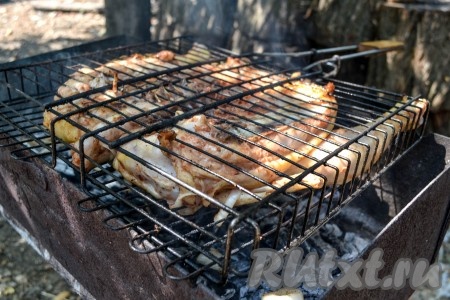 Замаринованную тушку курицы вместе с луком выложить на решетку и отправить на мангал. Угли должны тлеть, а не гореть, иначе курица сгорит.
