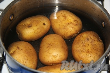 Картофель хорошо вымыть и, полностью залив холодной водой, поставить на огонь. Сварить картофель до готовности (готовая картошка будет легко прокалываться ножом или вилкой, но развариться она не должна, клубни должны остаться целыми).