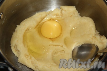 Тесто немного остудить, а затем добавлять по одному яйца. После добавления каждого яйца тщательно перемешивать тесто, пока оно не станет однородным.
