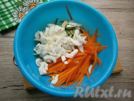 Вареные яйца разделить на белки и желтки. Желтки оставить для заправки. А белки нарезать широкой соломкой и добавить в салат из курицы и огурцов. Сырую морковь очистить, с помощью овощечистки нарезать тонкими слайсами (или же натереть морковку на крупной или корейской тёрке) и выложить в салат.