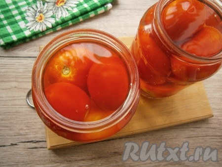 Залить помидоры крутым кипятком, прикрыть крышками, оставить на 15 минут. Затем воду слить в раковину и снова залить помидоры кипятком, оставить на 10 минут.
