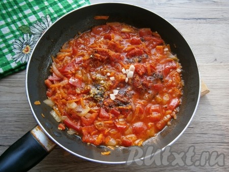 Протушить овощи на небольшом огне 3-5 минут. Всыпать соль по вкусу, сахар, черный молотый перец и специи. Добавить измельченный чеснок, потушить томатный соус еще 2-3 минуты.
