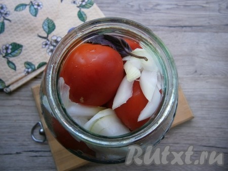 Далее доверху наполнить банку помидорами и разместить оставшийся лук и пару листиков базилика.

