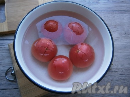 Залить помидоры кипятком на 1-2 минуты, после чего обдать холодной водой.
