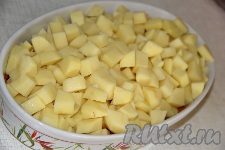 Очищенный картофель нарезать средними кубиками, выложить в форму поверх обжаренных овощей.
