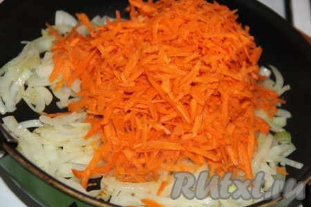 Морковь очистить, натереть на крупной тёрке и выложить в сковороду к обжаренному луку.
