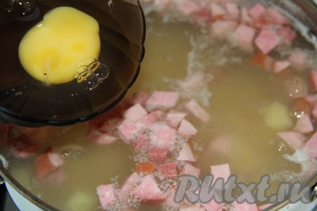 Яйца по одному вбить в пиалку и аккуратно влить в кипящий суп.
