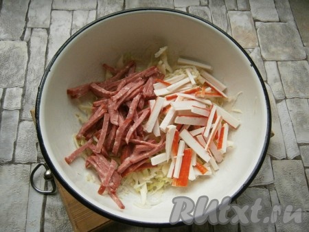Крабовые палочки и копченую колбасу нарезать брусочками или соломкой и добавить к капусте.

