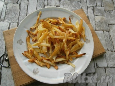 Обжарить картофель, помешивая, на среднем огне с добавлением 2 столовых ложек растительного масла до румяности. Выложить картофель на тарелку, дать остыть.