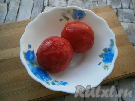 Два помидора залить кипятком на несколько минут и очистить от шкурки.