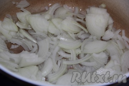 В толстостенную кастрюлю влить растительное масло, выложить лук, нарезанный на тонкие полукольца.
