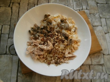 Куриное мясо, маринованные шампиньоны, яйца и жареный лук соединить в тарелке, добавить рубленные грецкие орехи.
