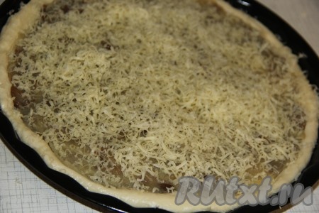 Оставить дрожжевой пирог с картошкой и грибами для расстойки на 30 минут. Затем посыпать верх пирога тёртым сыром.
