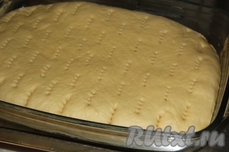 Оставить дрожжевой пирог с вареньем, накрыв форму пищевой плёнкой, на 1 час для расстойки. Пирог увеличится в объёме и поднимется в форме. Наколоть пирог с помощью вилки, прокалывая до самого дна.
