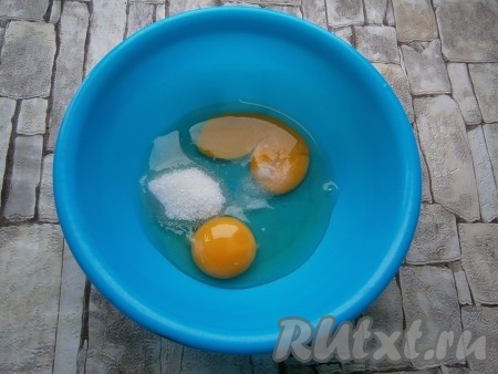 В миску вбить два сырых яйца, добавить сахар и щепотку соли.