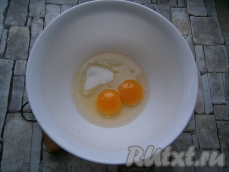 В миску разбить куриные яйца, добавить соль и сахар.