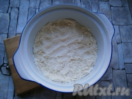 Форму для запекания диаметром около 18-20 см смазать сливочным маслом и высыпать половину крошки.