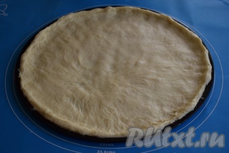 Далее в форму, в которой будете печь пиццу, выкладываем тесто и разравниваем его (при желании, перед выкладыванием теста форму можно смазать маслом).
