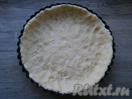 В круглую форму диаметром 22-23 см выложить тесто, растягивая его и формируя бортики, наколоть вилкой.