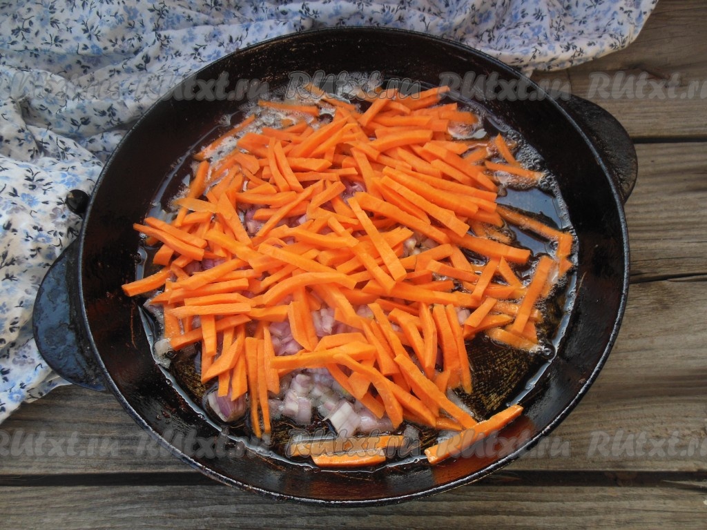 Обжаренное мясо уберите со сковороды. Добавьте в сковороду 100 мл растительного масла, выложите морковку с луком и обжарьте на среднем огне до золотистого цвета, иногда помешивая.
